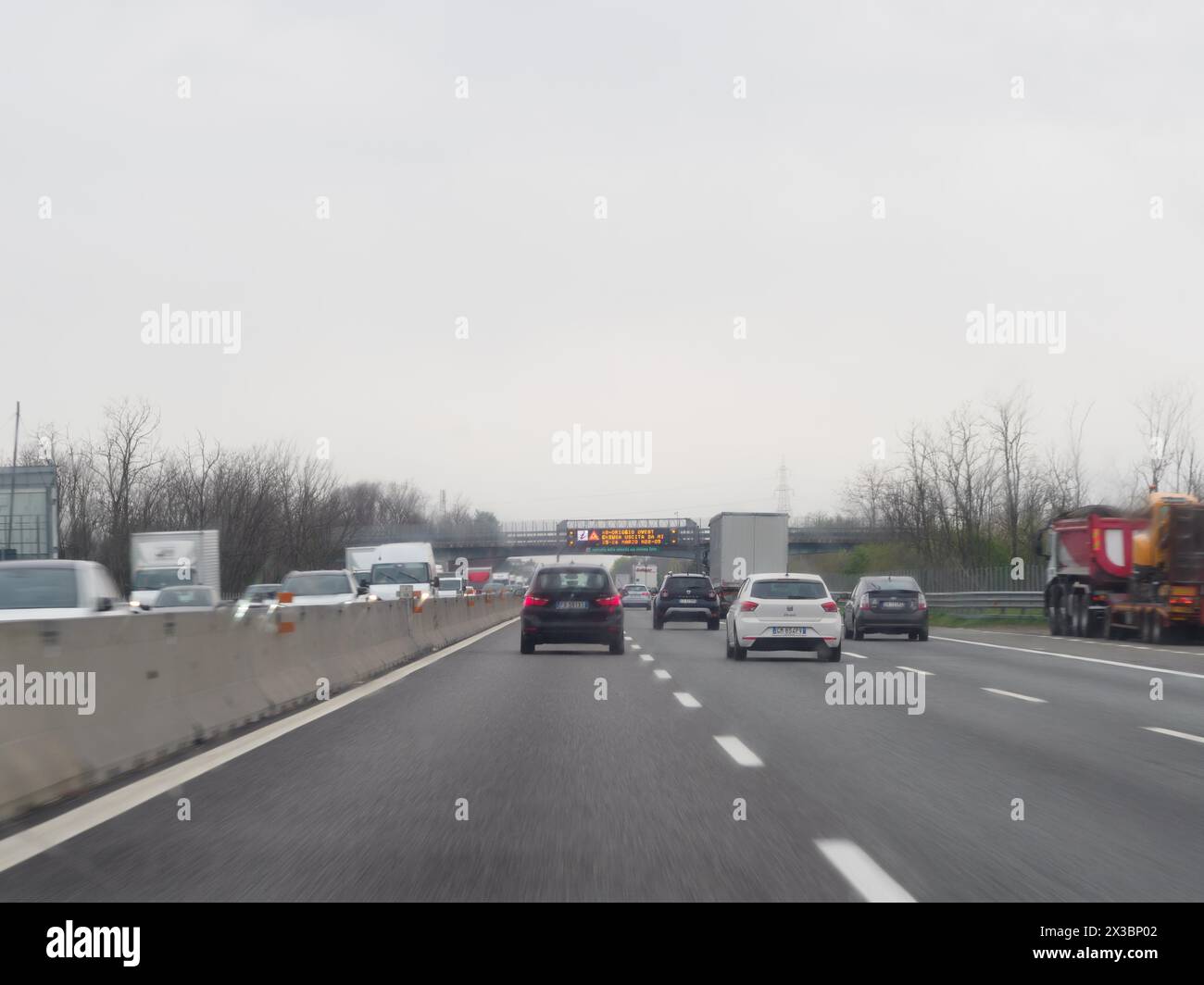 Cars on a highway with a digital traffic sign displaying a message