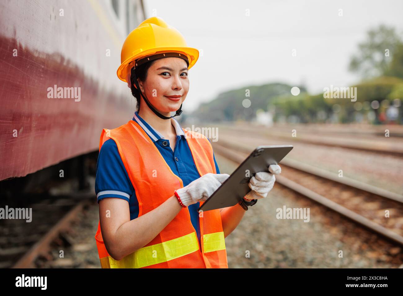 Train locomotive engineer women worker. Young teen Asian working check service maintenance train using tablet computer software. Stock Photo