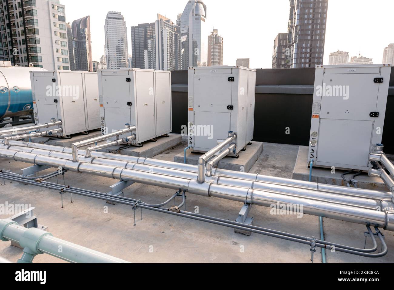 Heat pump Compressor hot water supply by heat exhanger to heating water for hotel or large commercial building roof top outdoor installation. Stock Photo