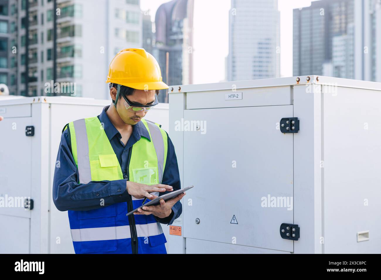 engineer male technician worker working service commercial building heat pump hot water supply systems. man safety checking maintenance heating water Stock Photo