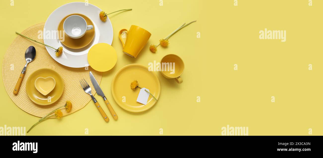 Beautiful table setting with dandelions flowers on yellow background with space for text Stock Photo