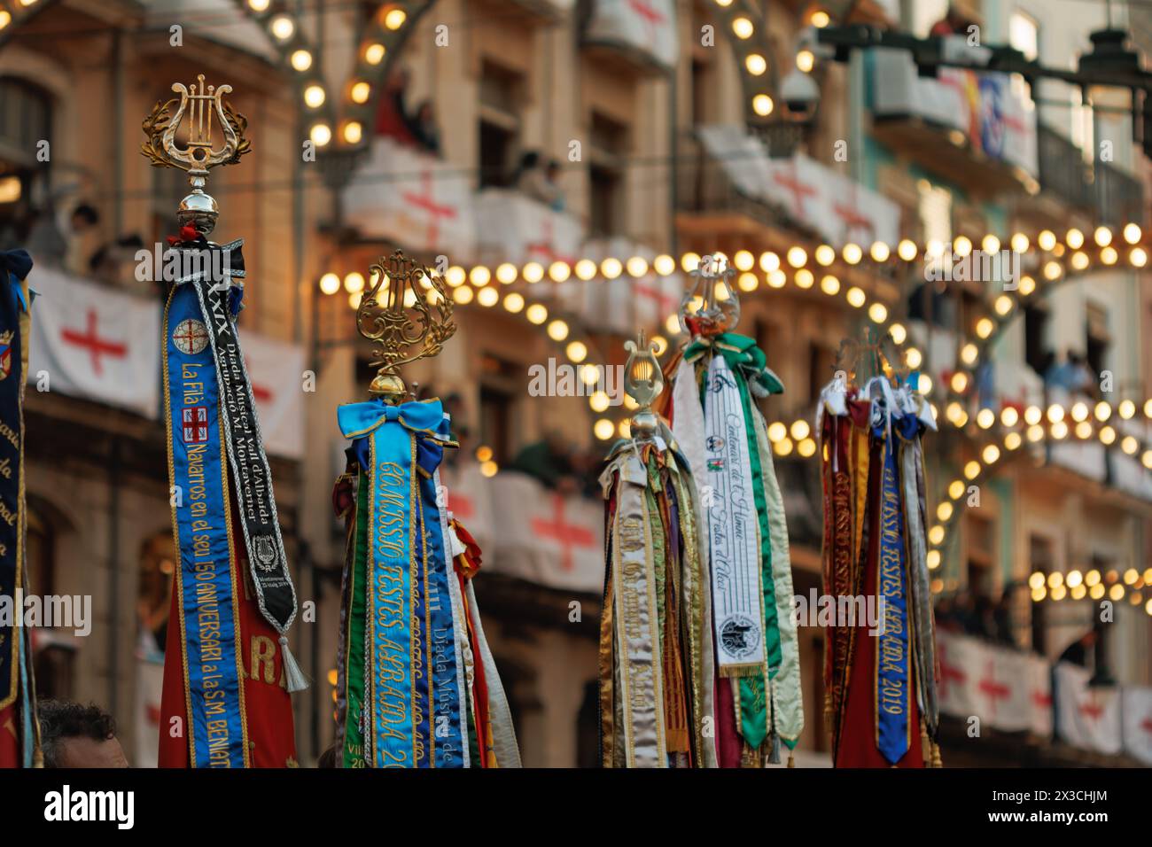 Flags of music bands with lighting background and balconies decorated with the flag of Saint George during the pasodoble festival in Alcoy Stock Photo