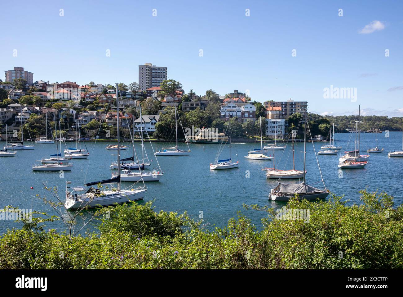 Mosman Bay on Sydney lower north shore, boats and sail yachts Moore din the bay, view from Cremorne point walk across the bay to South Mosman wharf Stock Photo