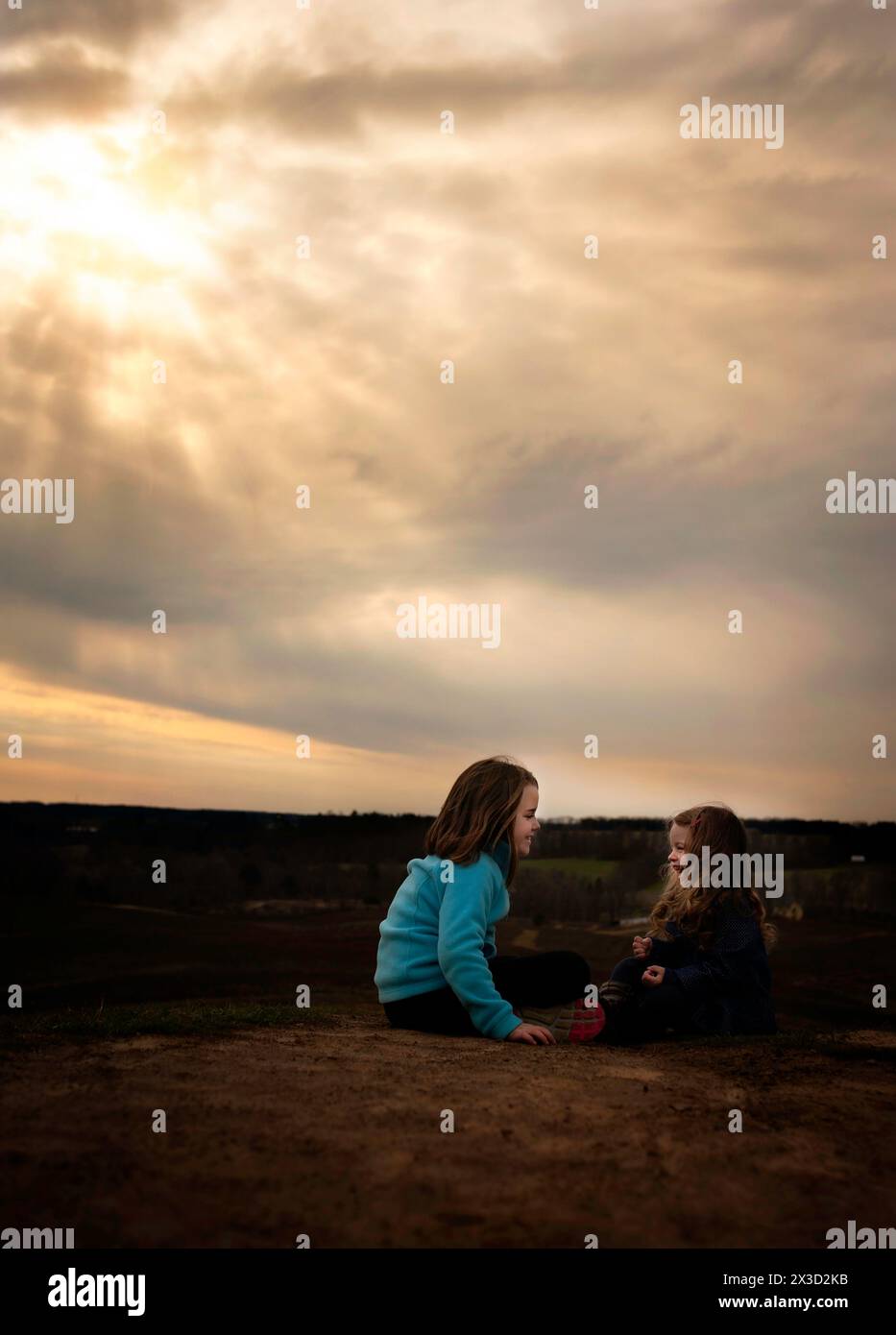 Beautiful sisters smiling and laughing outdoors at sunset Stock Photo ...