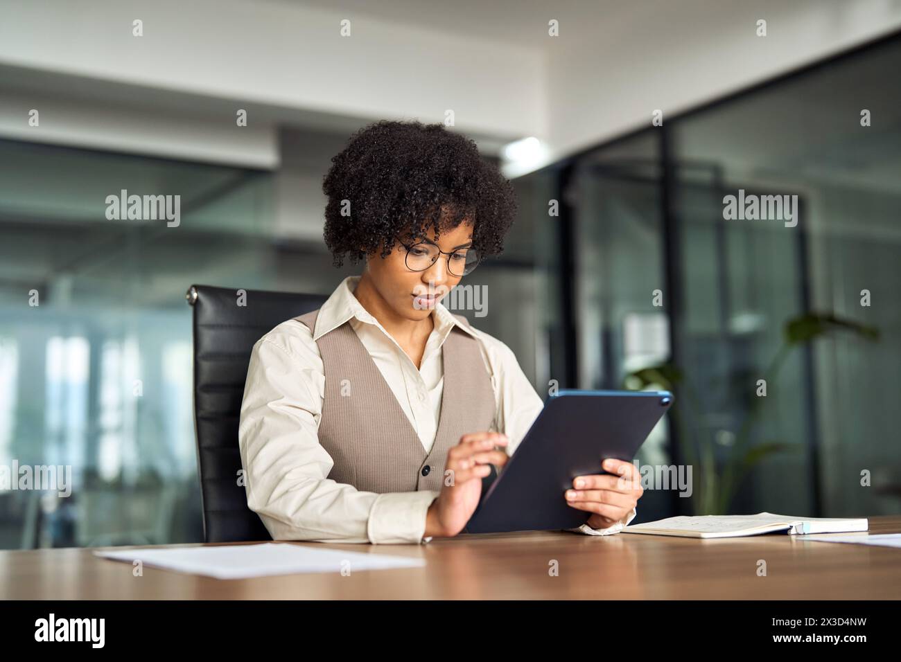 Young busy African business woman manager using tablet working in office. Stock Photo