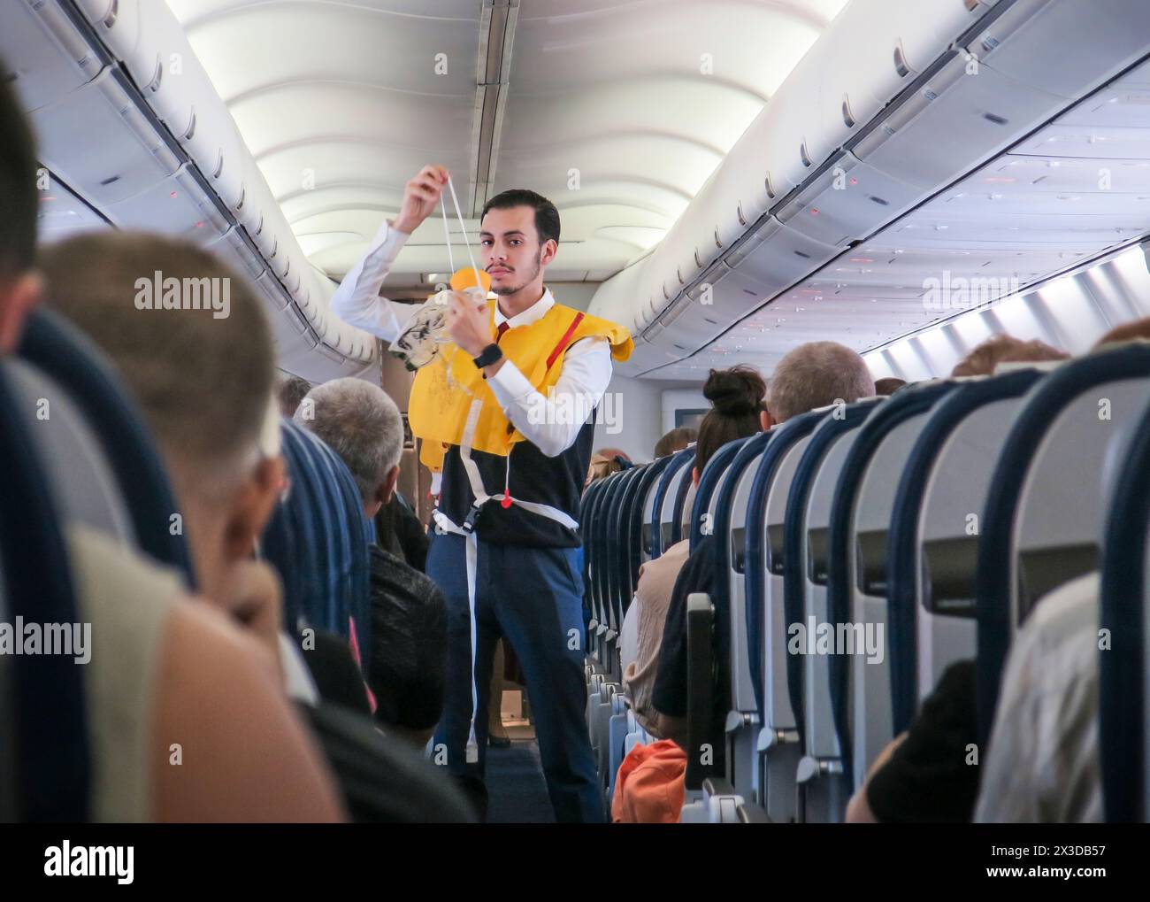 Flugzeug innen, Economy Class, Flugbegleiter erläutert die Sicherheitsmaßnahmen, Atemmaske - NO MODEL RELEASE! Stock Photo