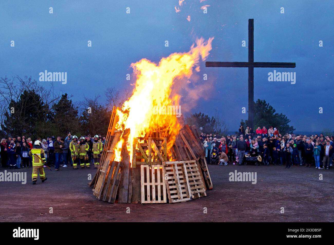 Fire brigade has lit the Easter bonfire on the Haniel spoil tip in front of the summit cross, Germany, North Rhine-Westphalia, Ruhr Area, Bottrop Stock Photo