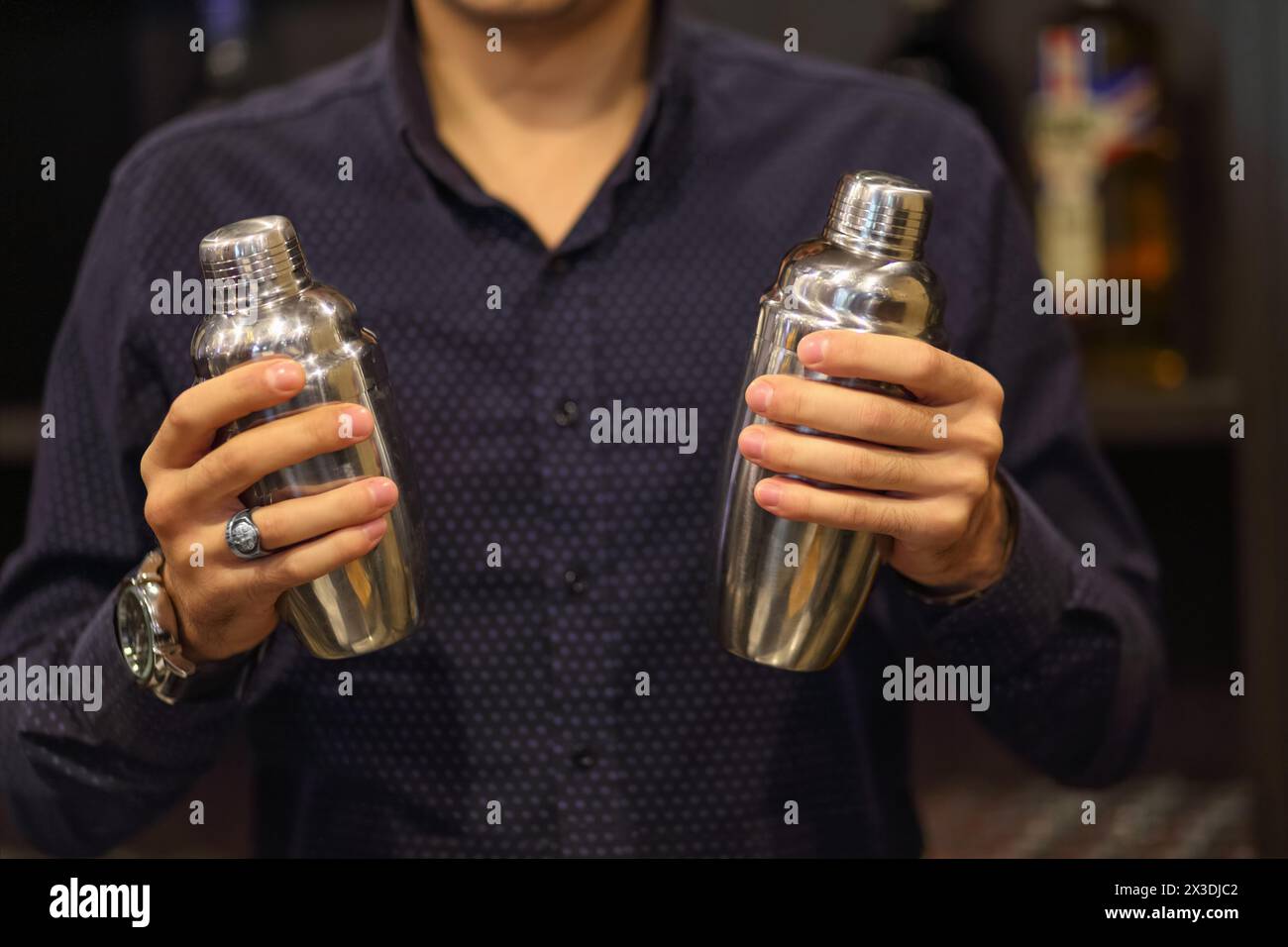 Young barman in bar interior shaking and mixing alcohol cocktail Stock Photo