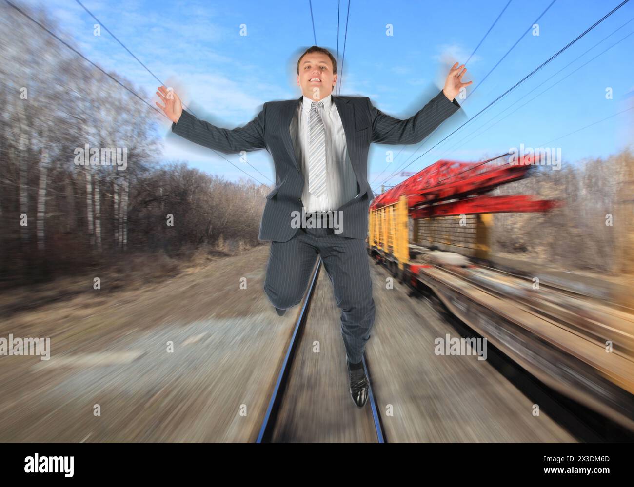 collage with businessman in black suit running away from train on background of railroad tracks, motion blur Stock Photo