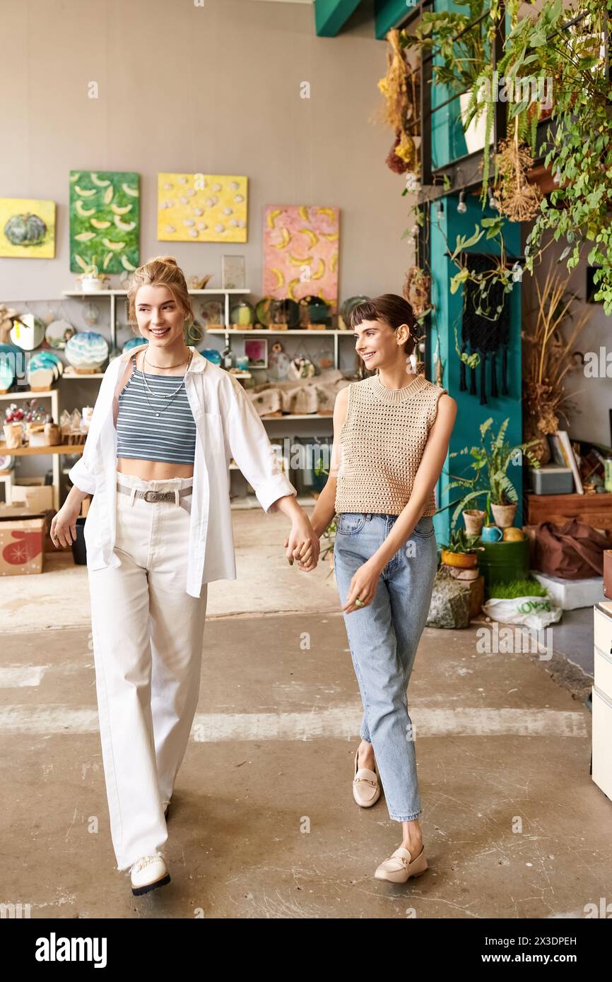 Two women peacefully stroll through the room, connected by their intertwined hands. Stock Photo
