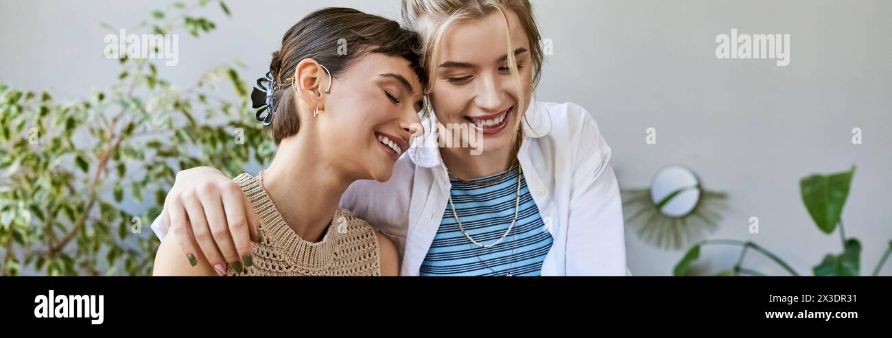 Two arty women, a loving lesbian couple, standing together at an art studio. Stock Photo