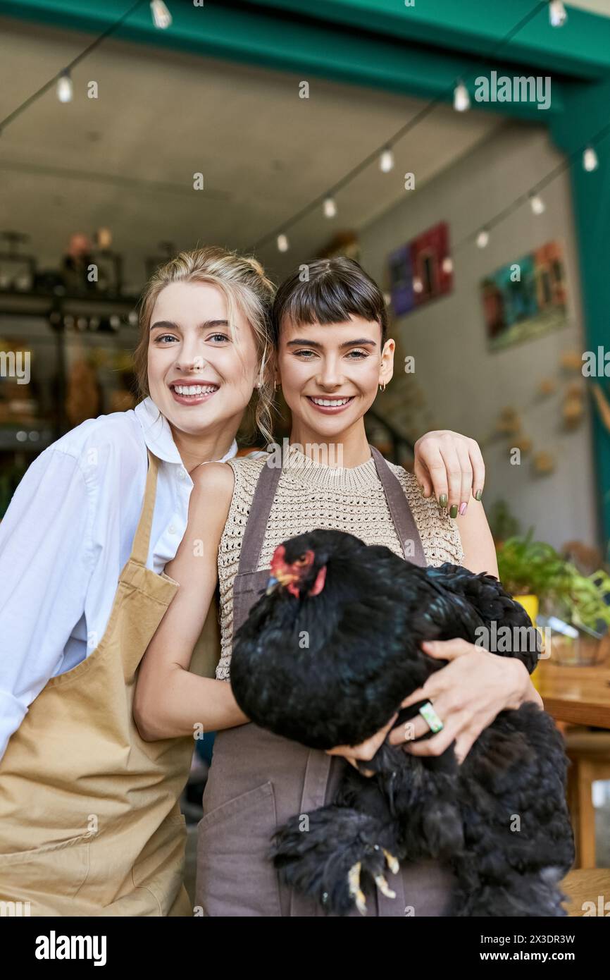 Two women hold a chicken in front of a store. Stock Photo