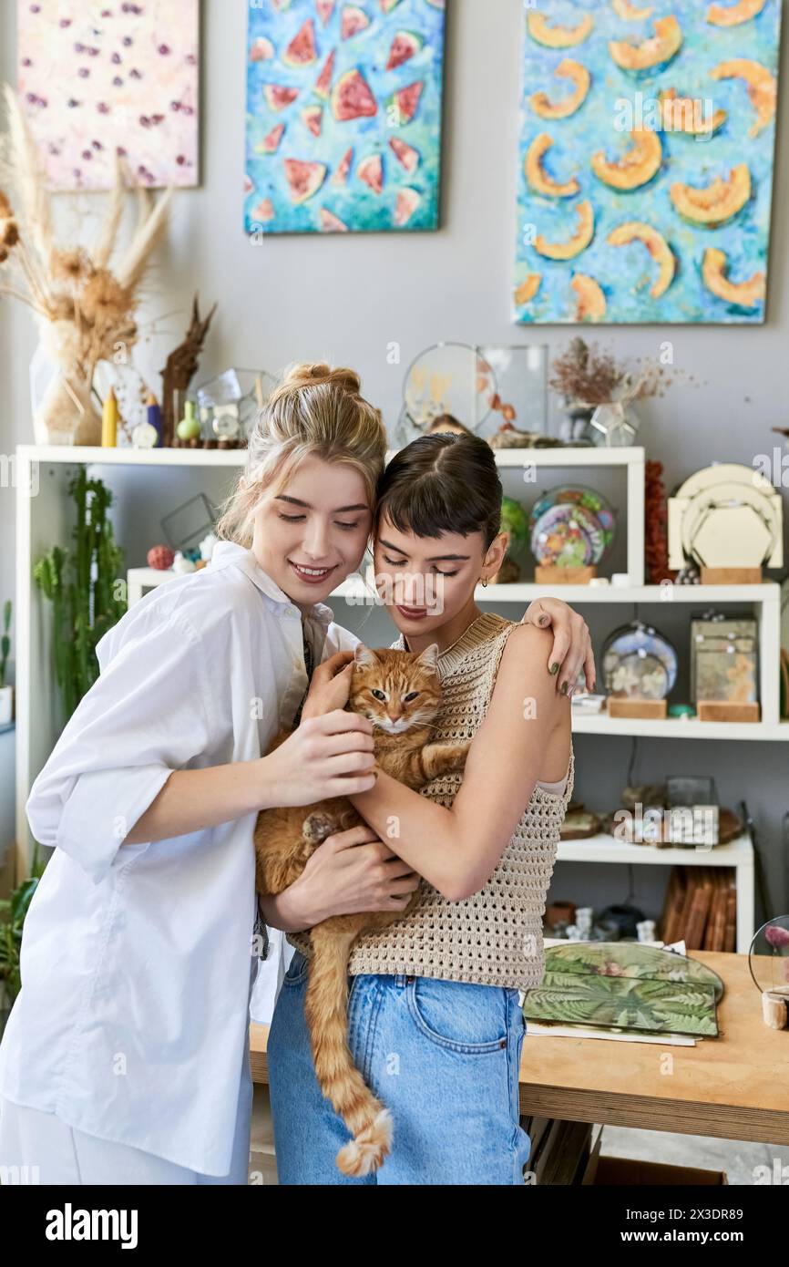 Two women cuddling a cat in a cozy room. Stock Photo