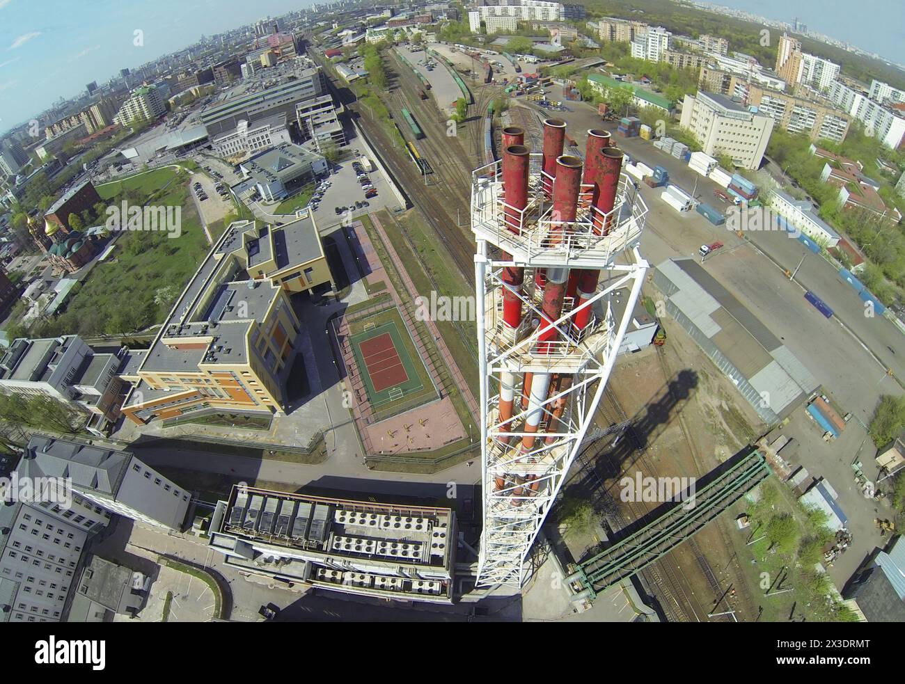 Tall tubes of boiler house near school and railway station at sunny day, aerial view Stock Photo