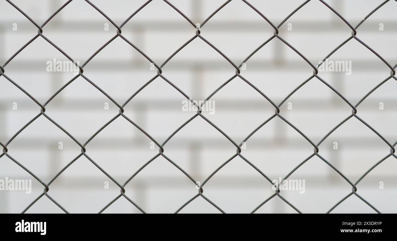 metal mesh and a brick wall behind it Stock Photo