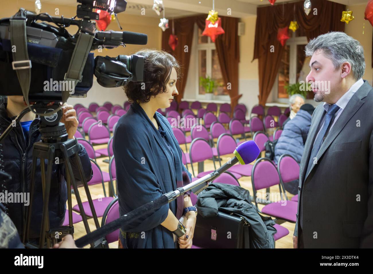 Council chair of deputy is giving interview to young journalist TV Stock Photo