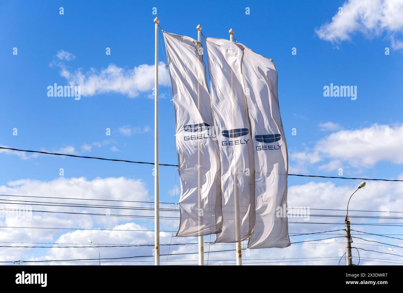 Samara, Russia - April 16, 2024: Geely dealership flags against a blue ...