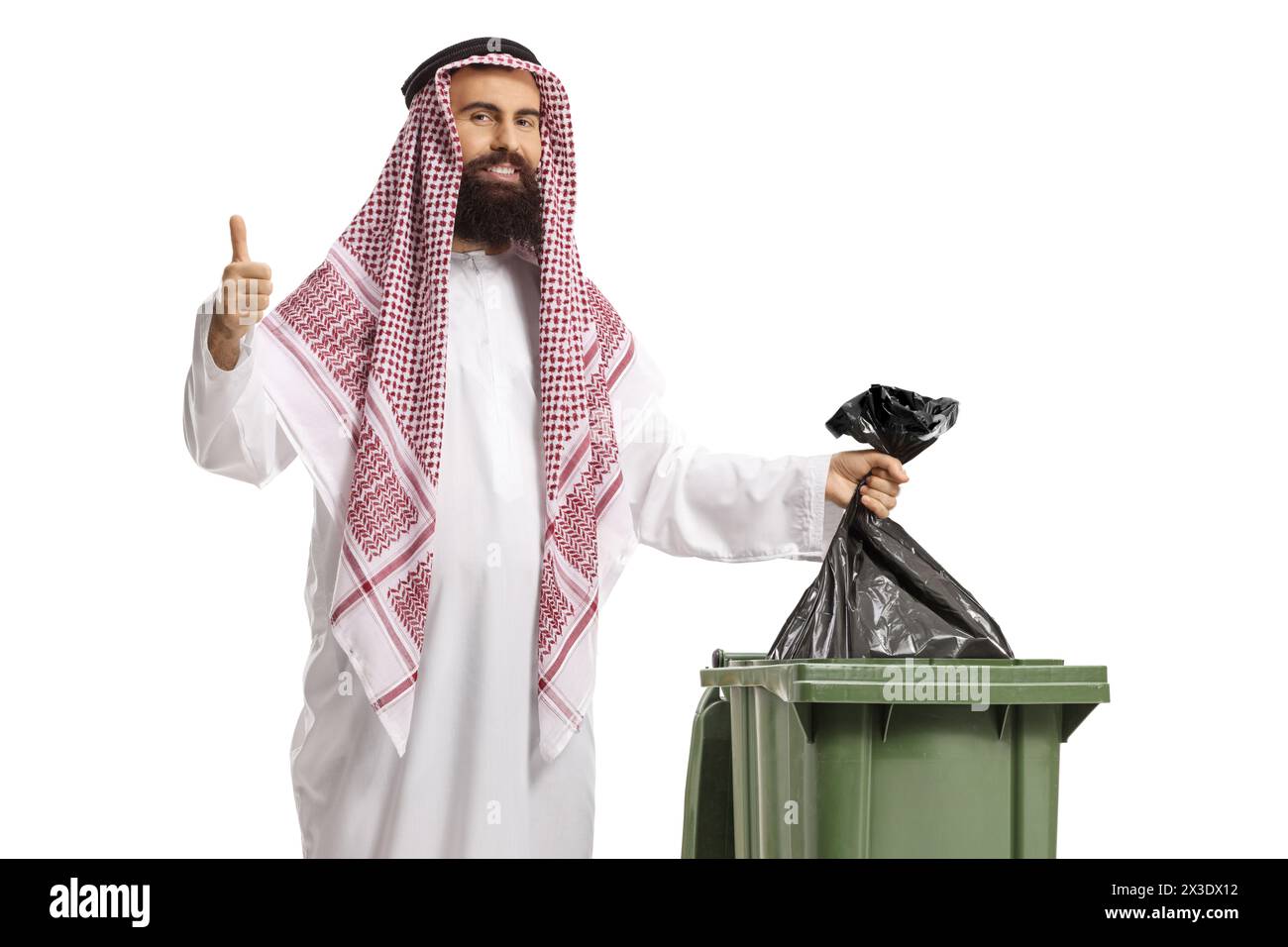 Saudi arab man throwing a plastic bag in a waste bin and showing thumbs up isolated on white background Stock Photo