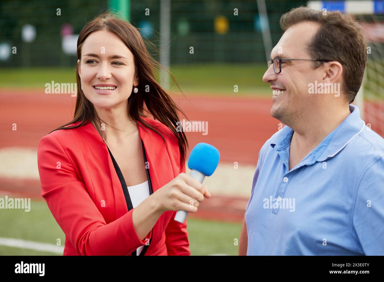 Young female journalist interviews man, focus on woman. Stock Photo