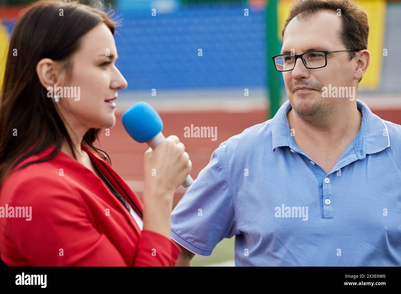Young female journalist interviews man, focus on man. Stock Photo