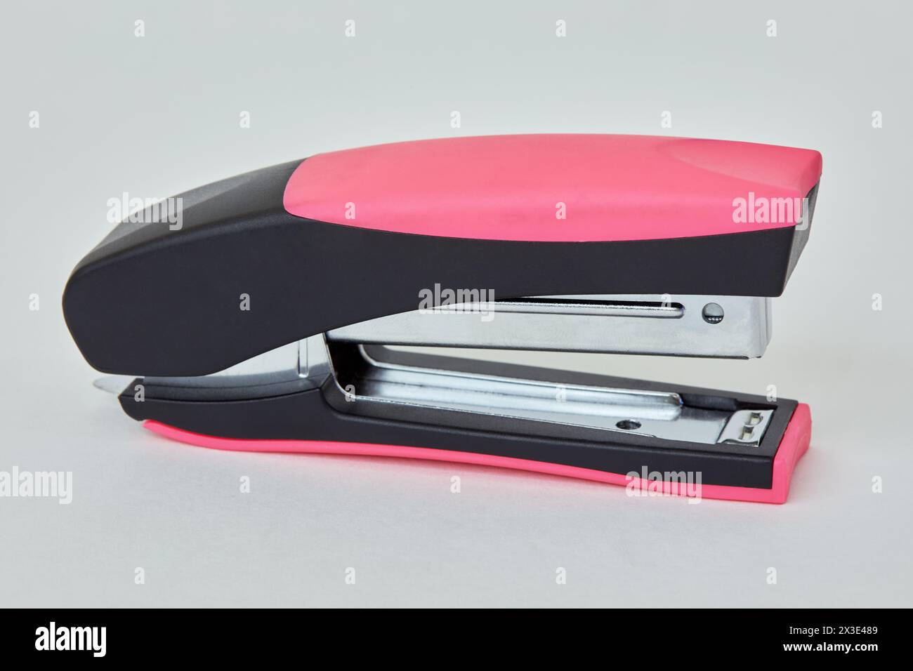 Black and pink stapler on white background. Stock Photo