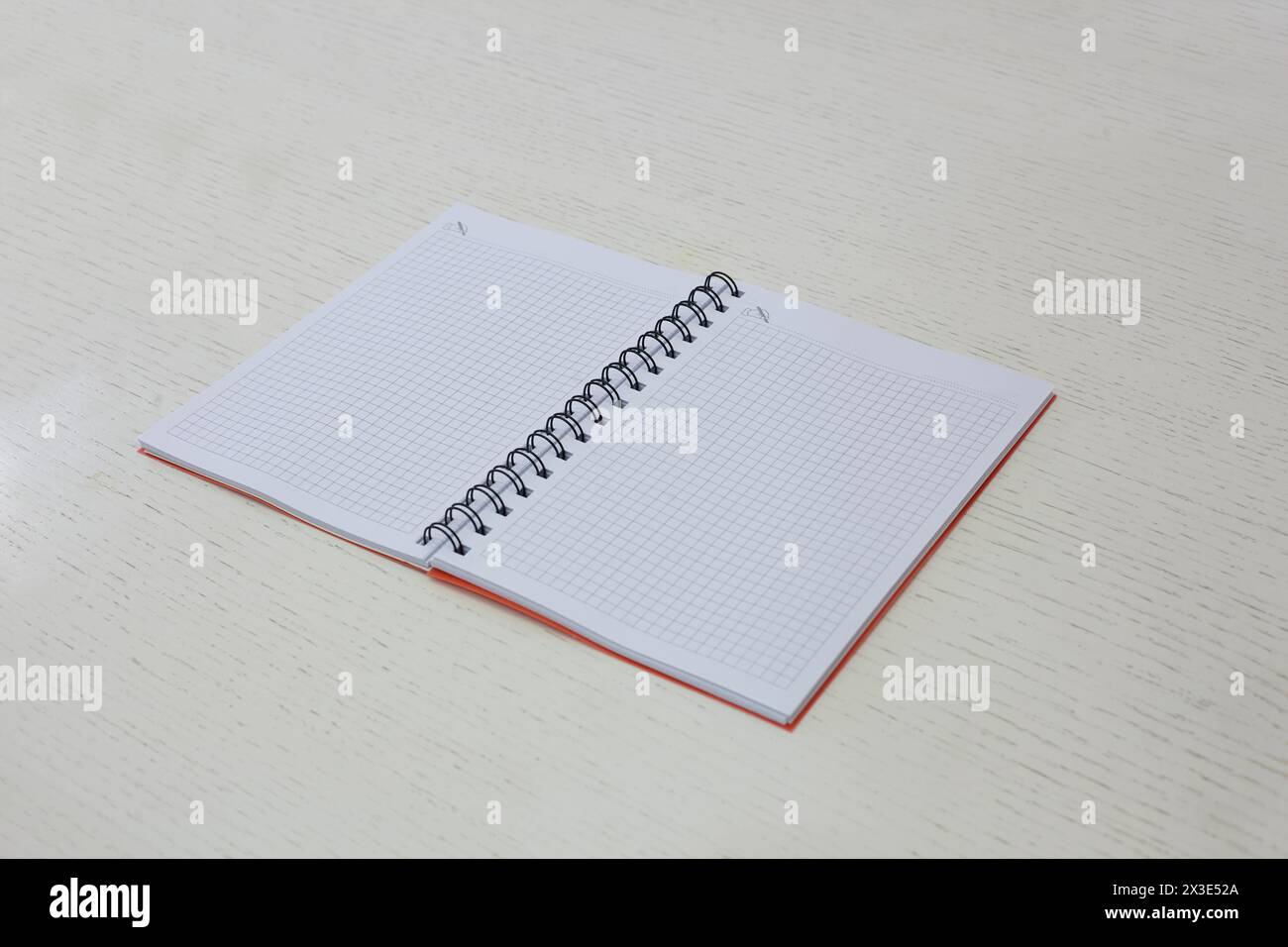 Squared notebook lying on table. Stock Photo