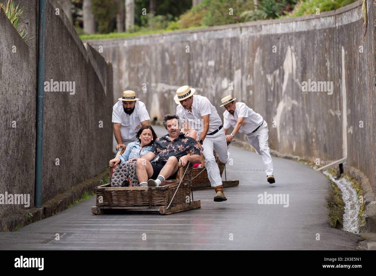 Tourist passengers ride Funchal's famous 'Carreiros de Monte' toboggan ride, on 19th April 2024, in Funchal, Madeira, Portugal.  (Extended caption in Additional Information). Stock Photo
