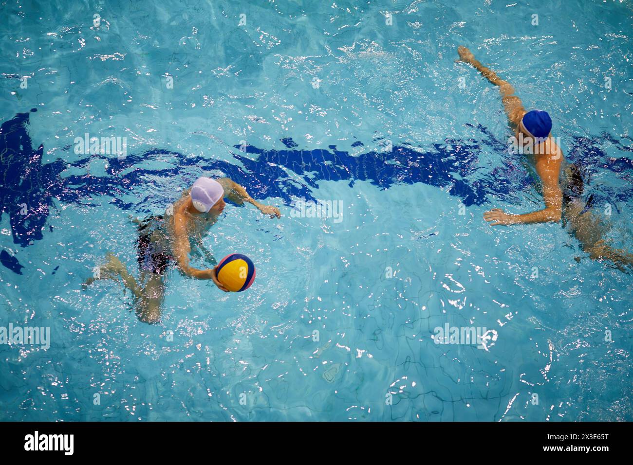 two Players of teams of friendly match on water polo in basin Swimming Competition Stock Photo