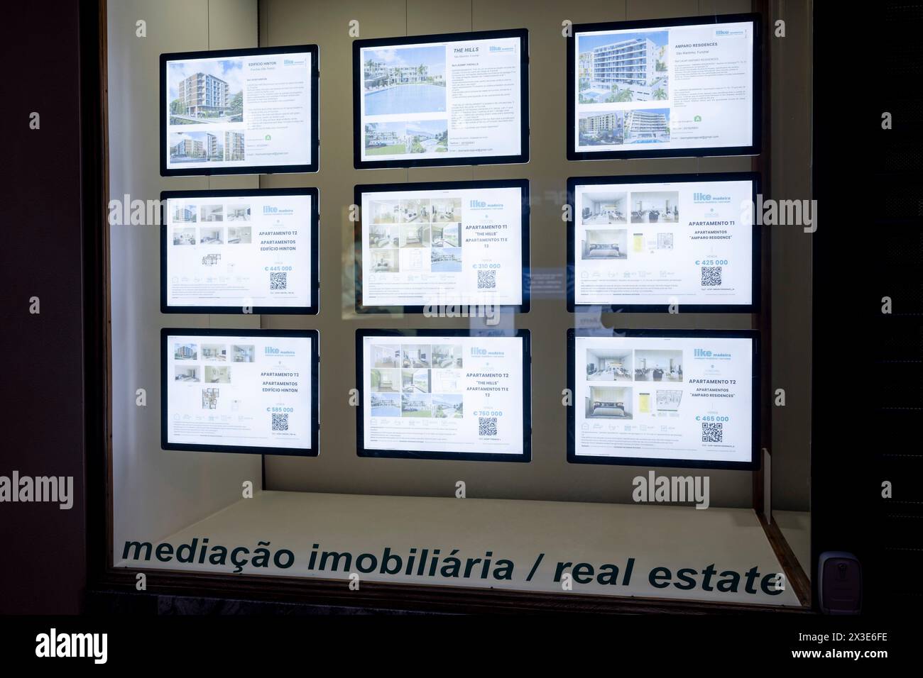 Properties for sale are seen in the window of an estate egent's window, on 18th April 2024, in Funchal, Madeira, Portugal. Stock Photo