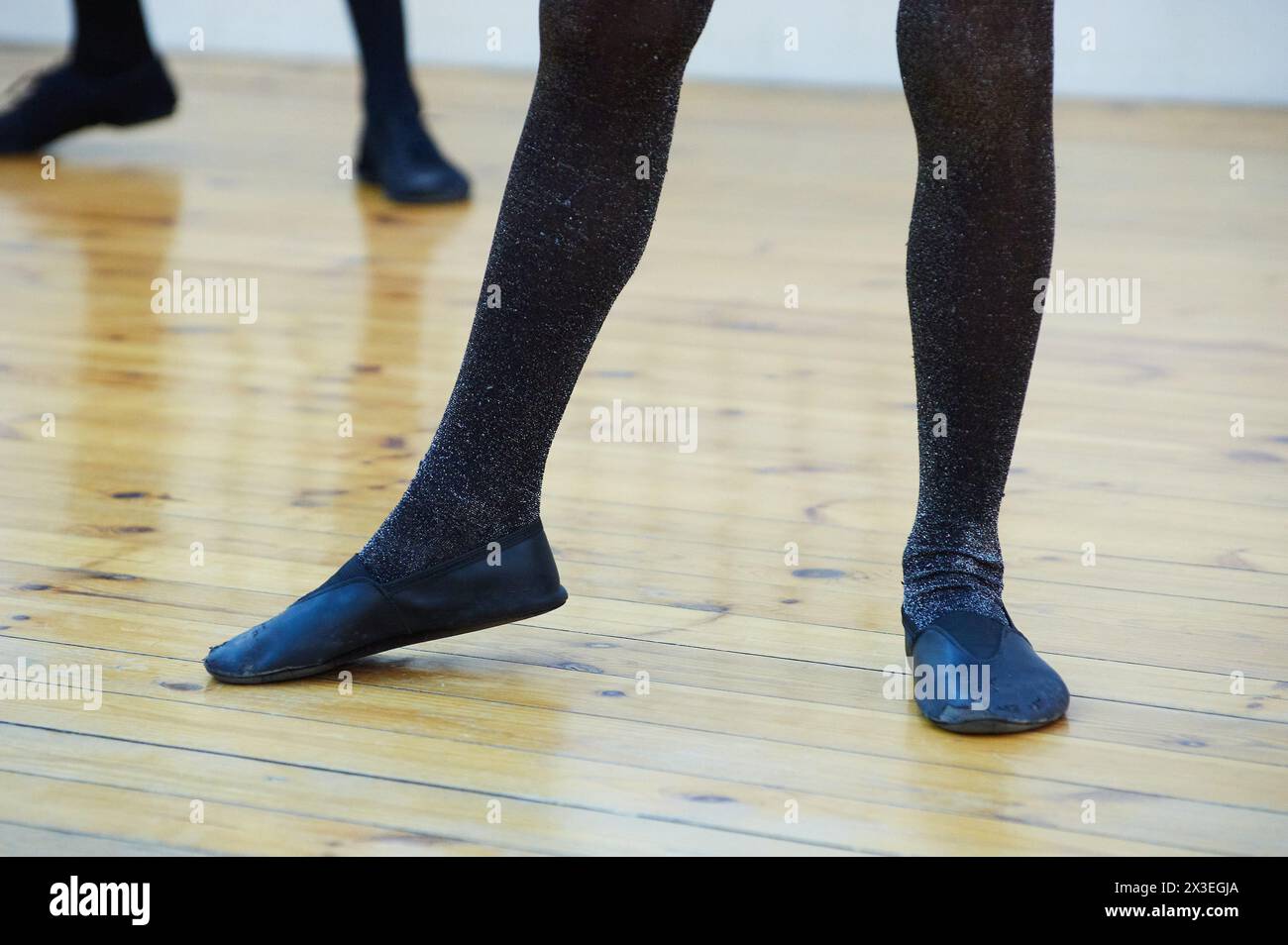 Closeup of two pairs of children legs wearing shimmery black tights