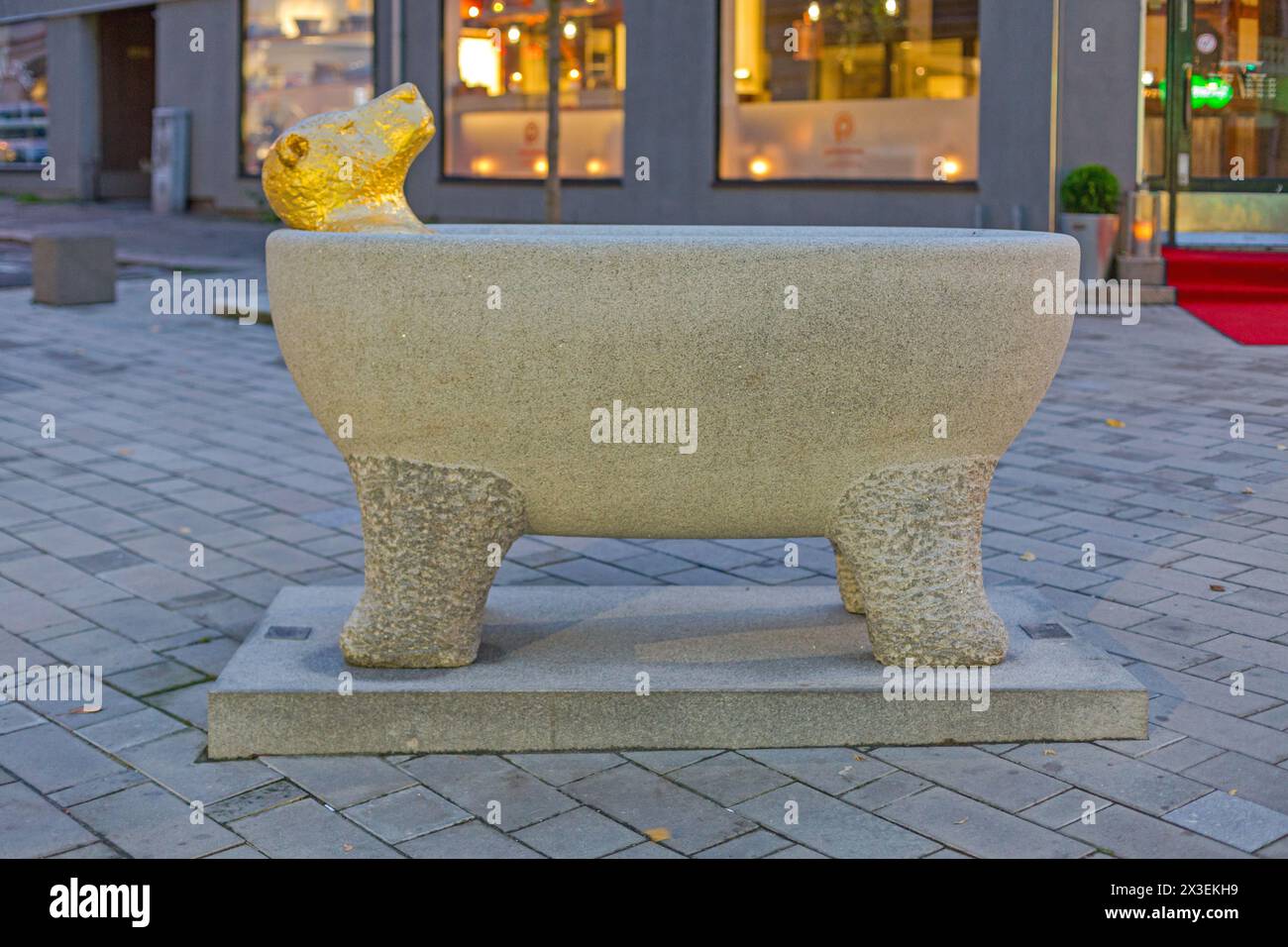 Sarpsborg, Norway - October 27, 2016: Sculpture of Gold Bear in Free Standing Bathtub at Sankt Marie Gate Autumn Evening. Stock Photo