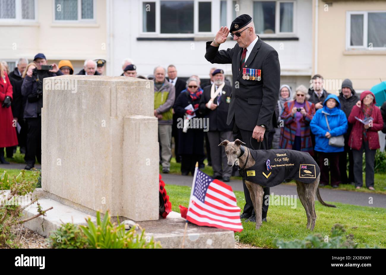 Former Royal Tank Regiment member Chris Lock salutes after laying a wreath with mascot of the Tank Memorial Ypres Salient, Lance Corporal Tilly, during a wreath laying service at the US D-Day Memorial in Victoria Gardens, Portland, to mark the 80th anniversary of Exercise Tiger, a Second World War training operation that went wrong off the Dorset coast. Picture date: Friday April 26, 2024. Stock Photo