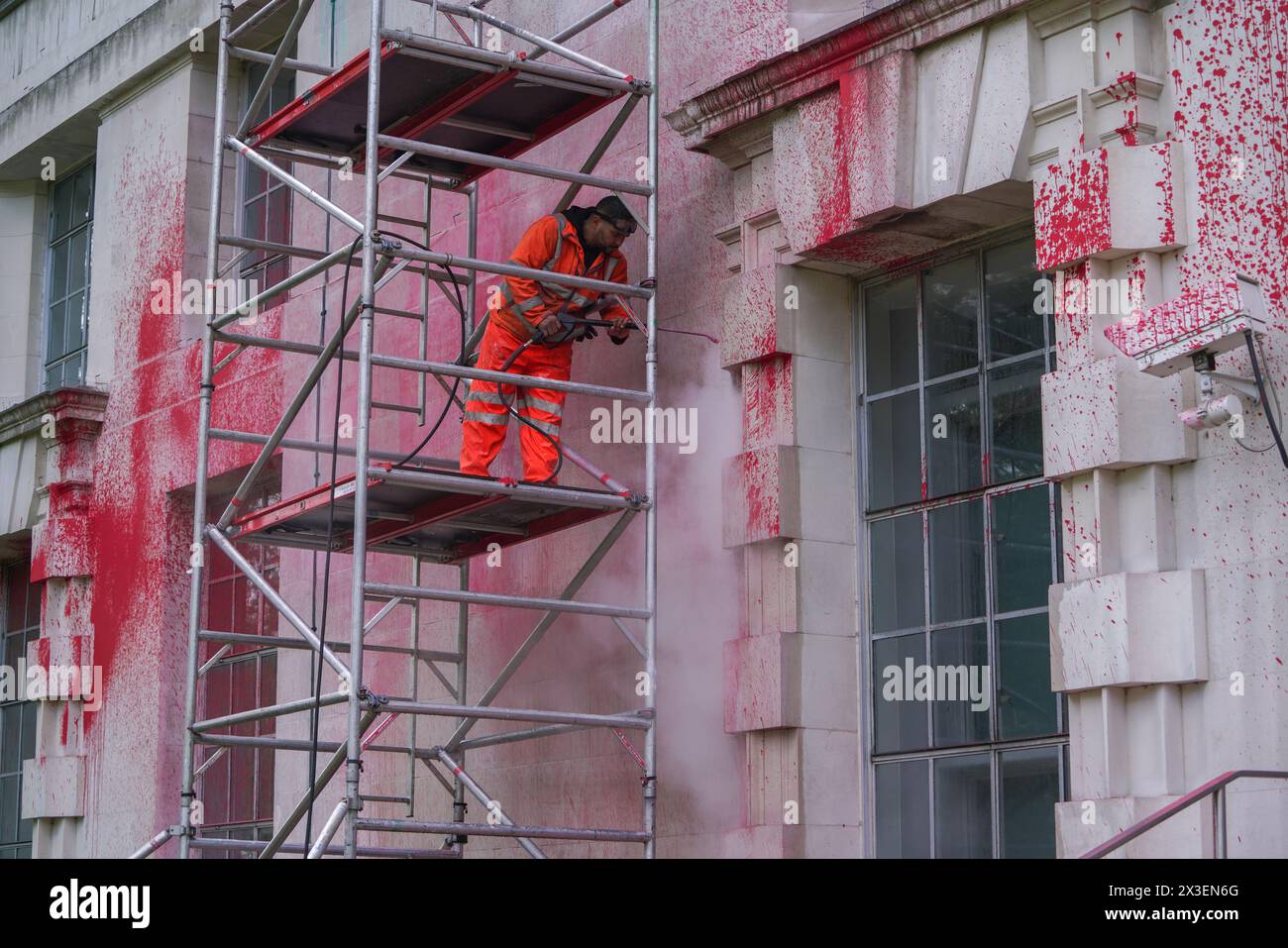 London, UK. 26th April, 2024.  A worker washes  the red paint with a power hose  which from walls of the Ministry of Defence London.   The Ministry of Defence was targeted by Pro Palestinian groups Youth Demand and Palestine Action  Credit: amer ghazzal/Alamy Live News Stock Photo