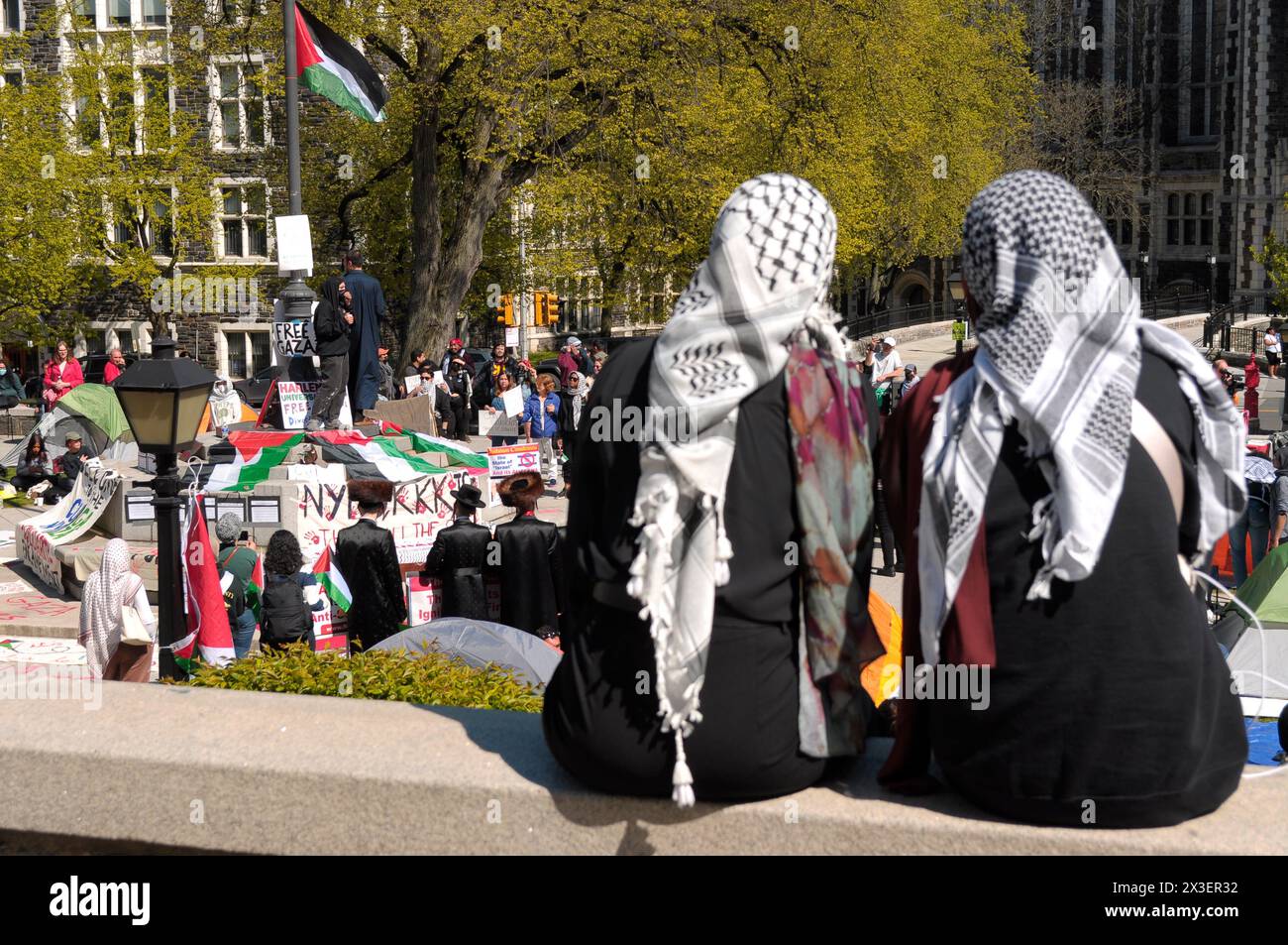 Two protesters wearing keffiyeh headdresses are seen at a pro-Palestine encampment at the City College of New York. Pro-Palestine demonstrators rallied in a courtyard in the City College of New York in Manhattan, New York City condemning the Israel Defense Forces' military operations in Gaza. Since Thursday morning, students and pro-Palestine activists at City College have held a sit-in protest on campus, forming a 'Gaza Solidarity Encampment.' The City College encampment follows a similar encampment that began in Columbia University in New York City last week. Encampments have been forming in Stock Photo