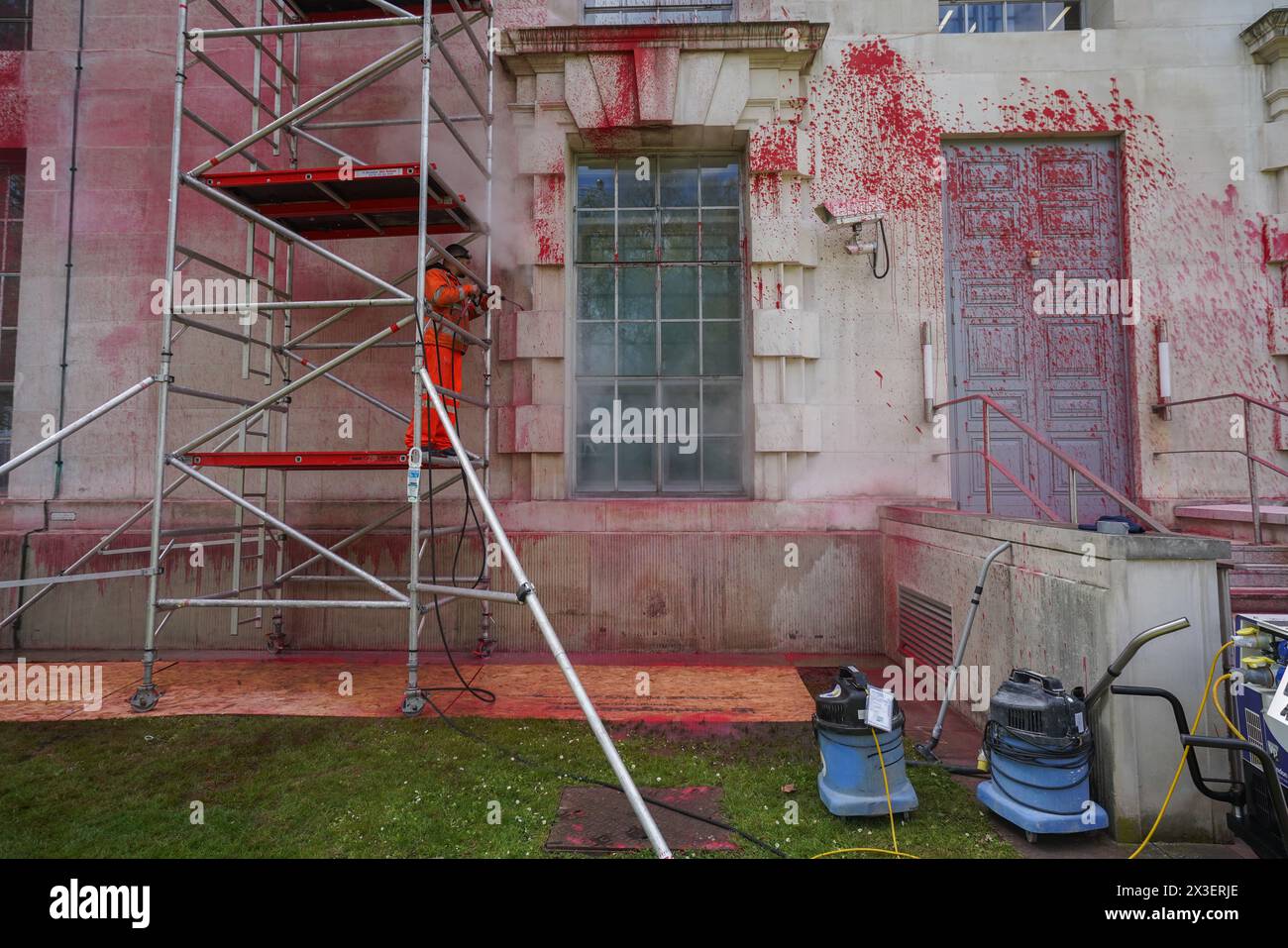 London, UK. 26th April, 2024.  A worker washes  the red paint with a power hose  which from walls of the Ministry of Defence London.   The Ministry of Defence was targeted by Pro Palestinian groups Youth Demand and Palestine Action  Credit: amer ghazzal/Alamy Live News Stock Photo