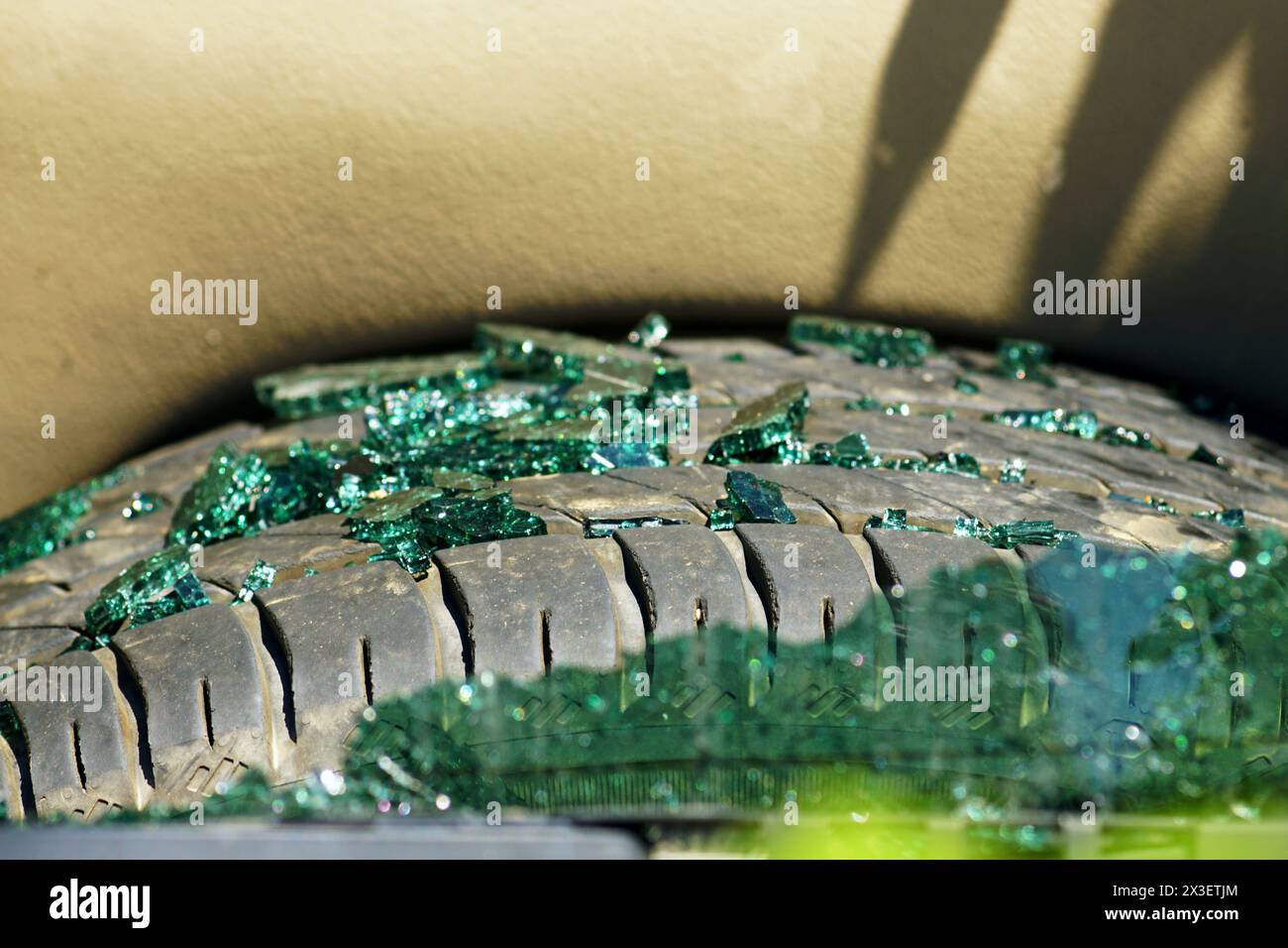 Pieces of a broken rear window of a car lying on a spare tire. Stock Photo