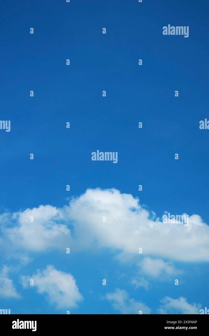 White Fluffy Clouds Floating on Vivid Blue Sky Stock Photo