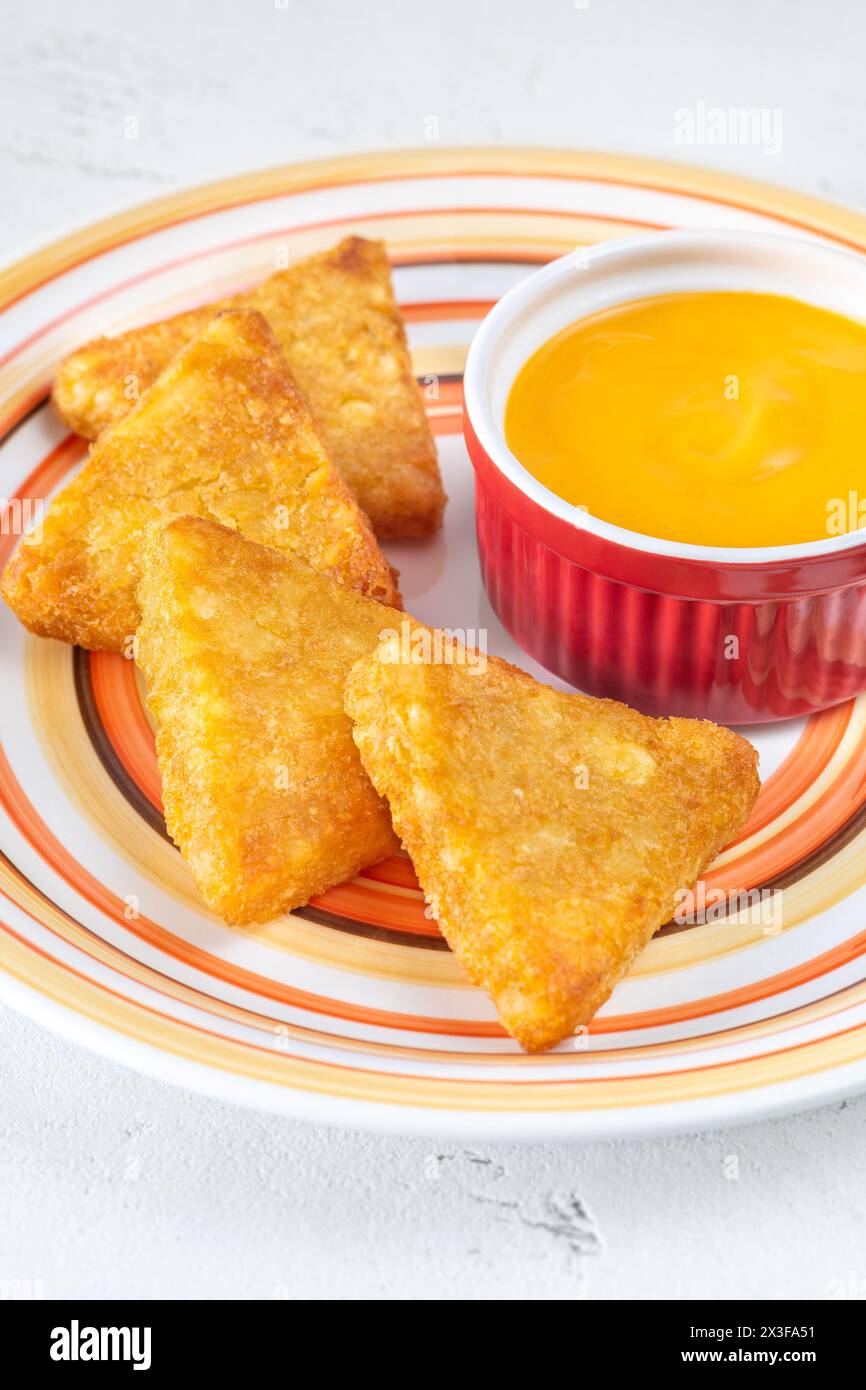 Hash Browns patties with cheddar cheese sauce Stock Photo