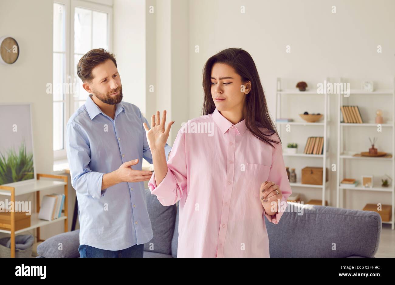 Emotionally stressed young couple arguing angrily at home during family conflict. Stock Photo