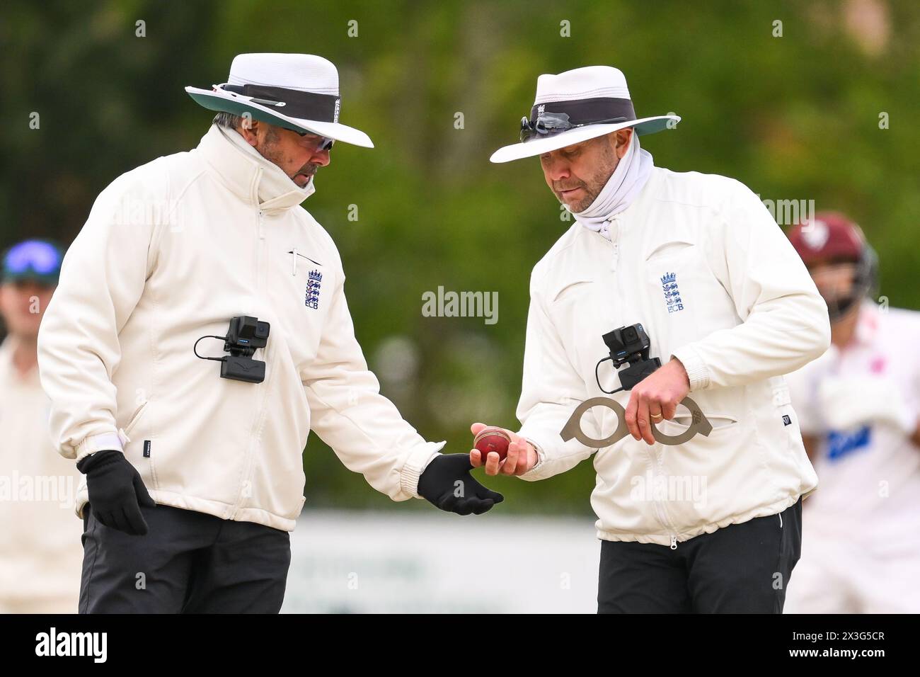 Umpires Mike Burns and Richard Illingworth check the ball shape during overs during the Vitality County Championship Division 1 match Worcestershire vs Somerset at Kidderminster Cricket Club, Kidderminster, United Kingdom, 26th April 2024  (Photo by Craig Thomas/News Images) Stock Photo