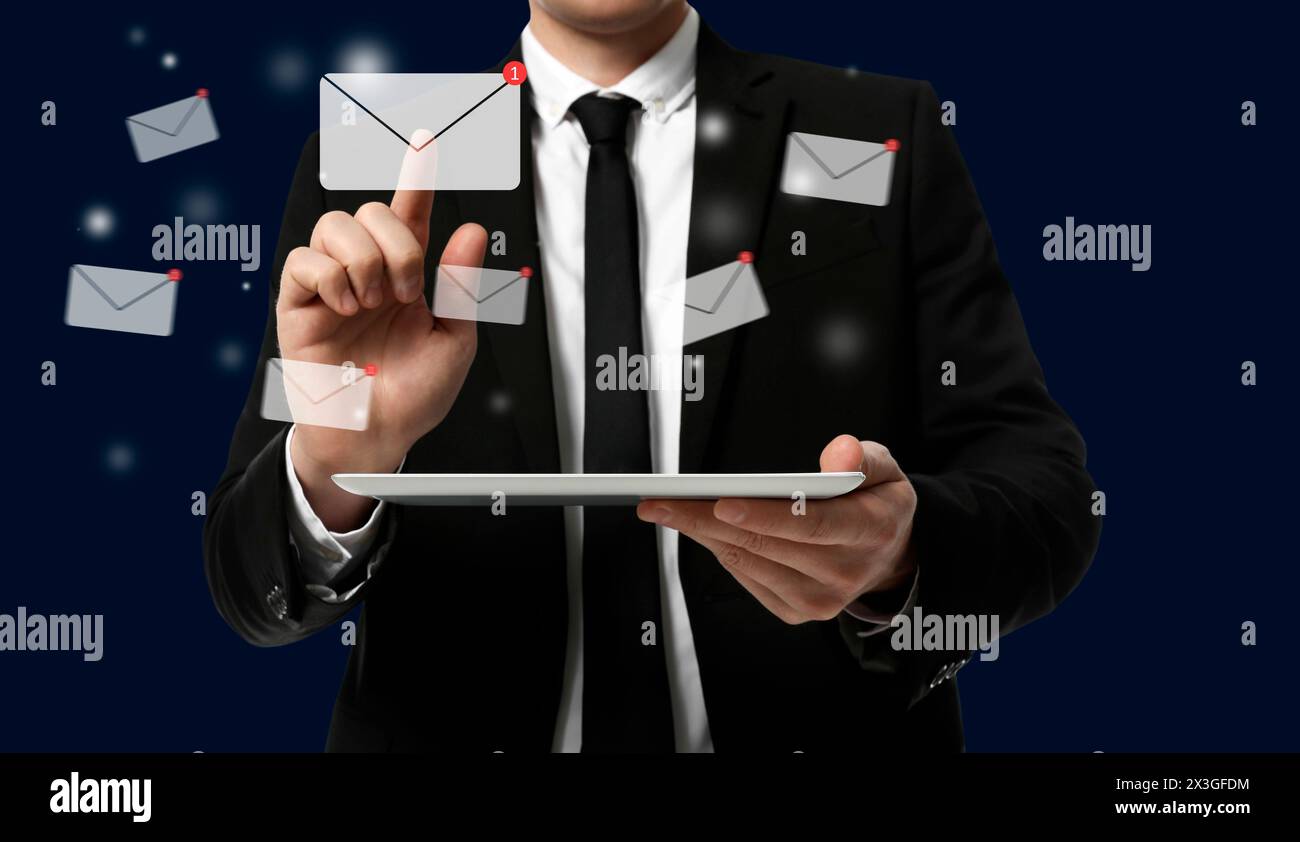 Incoming email. Man touching virtual envelope over tablet against dark blue background, closeup Stock Photo