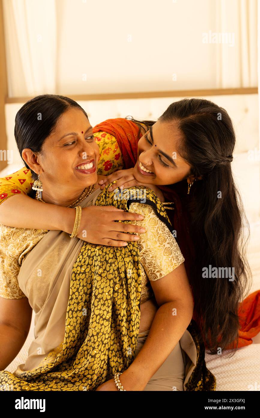 Indian mother and teenage daughter, embracing warmly, both showing joyful smiles Stock Photo