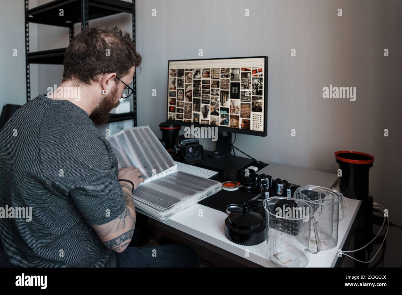 Photographer reviewing film negatives at a modern workstation Stock Photo