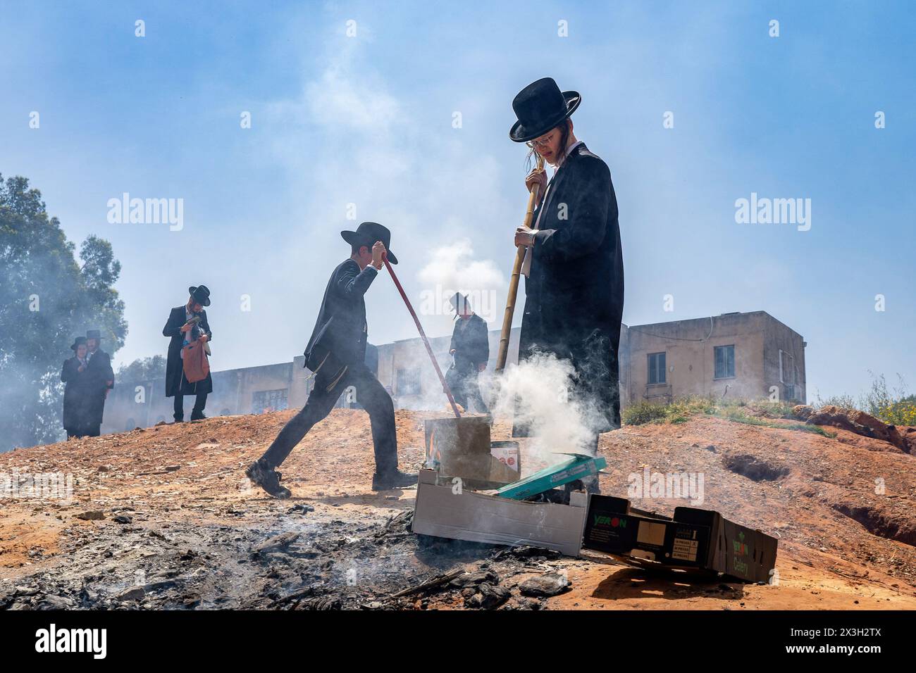 April 22, 2024, Bnei Brak, Israel: Young Jewish boys set up their private small fire. During the Biur Chametz, religious Jews fulfill their obligation to inspect their homes for any leaven and eliminate it before the night of Passover. In ultra-Orthodox cities in Israel, fires are set up in major locations in the city for this purpose, where people bring their bread leftovers to burn the leaven. During the seven days of Passover, they are prohibited from eating or possessing any leaven, symbolizing the dough the Israelites did not have time to allow to rise before the Exodus from Egypt. Biur C Stock Photo