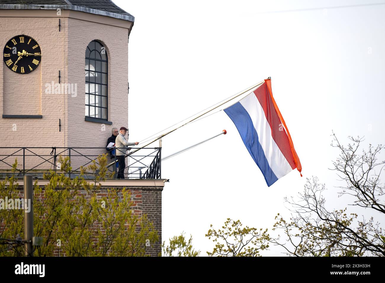 EMMEN - The Dutch flag is hoisted on the Grote Kerk for King's Day. While the royal family visits Emmen, the national holiday is also being fully celebrated in the rest of the country. ANP SANDER KONING netherlands out - belgium out Stock Photo