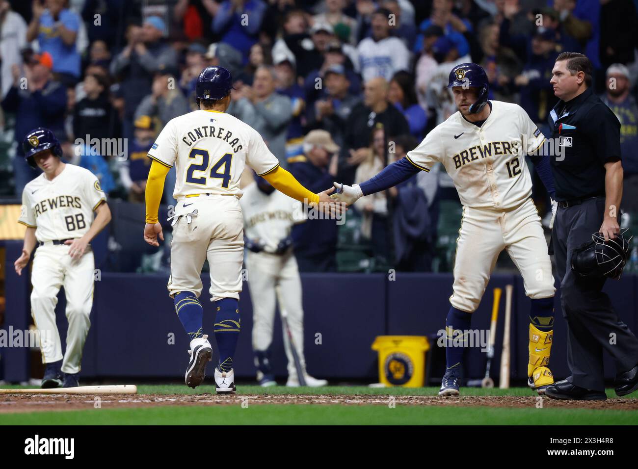 Milwaukee, WI, USA. 26th Apr, 2024. Milwaukee Brewers catcher William Contreras (24) scores and is congratulated by teammate first base Rhys Hoskins (12) during the game between the Milwaukee Brewers and the New York Yankees at American Family Field in Milwaukee, WI. Darren Lee/CSM/Alamy Live News Stock Photo