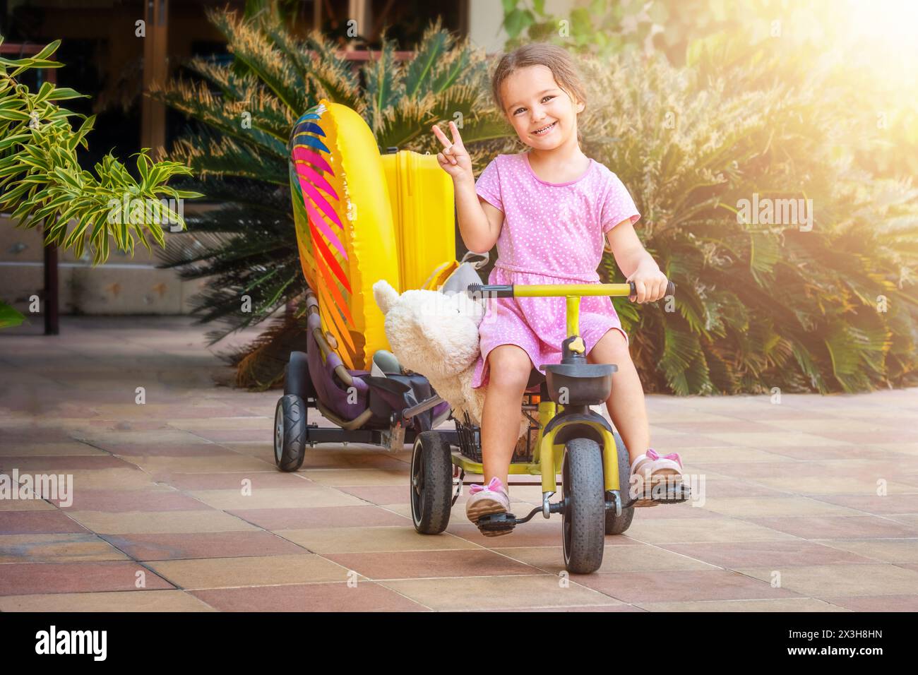 Portrait of a happy child riding a bicycle in the backyard Stock Photo