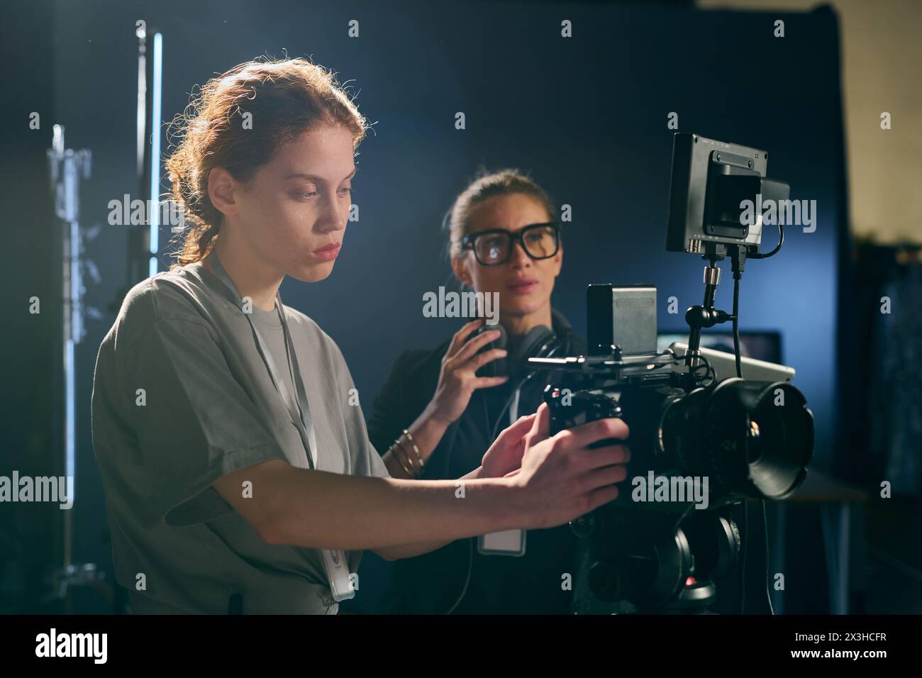 Side view portrait of female cameraman operating equipment on set with ...