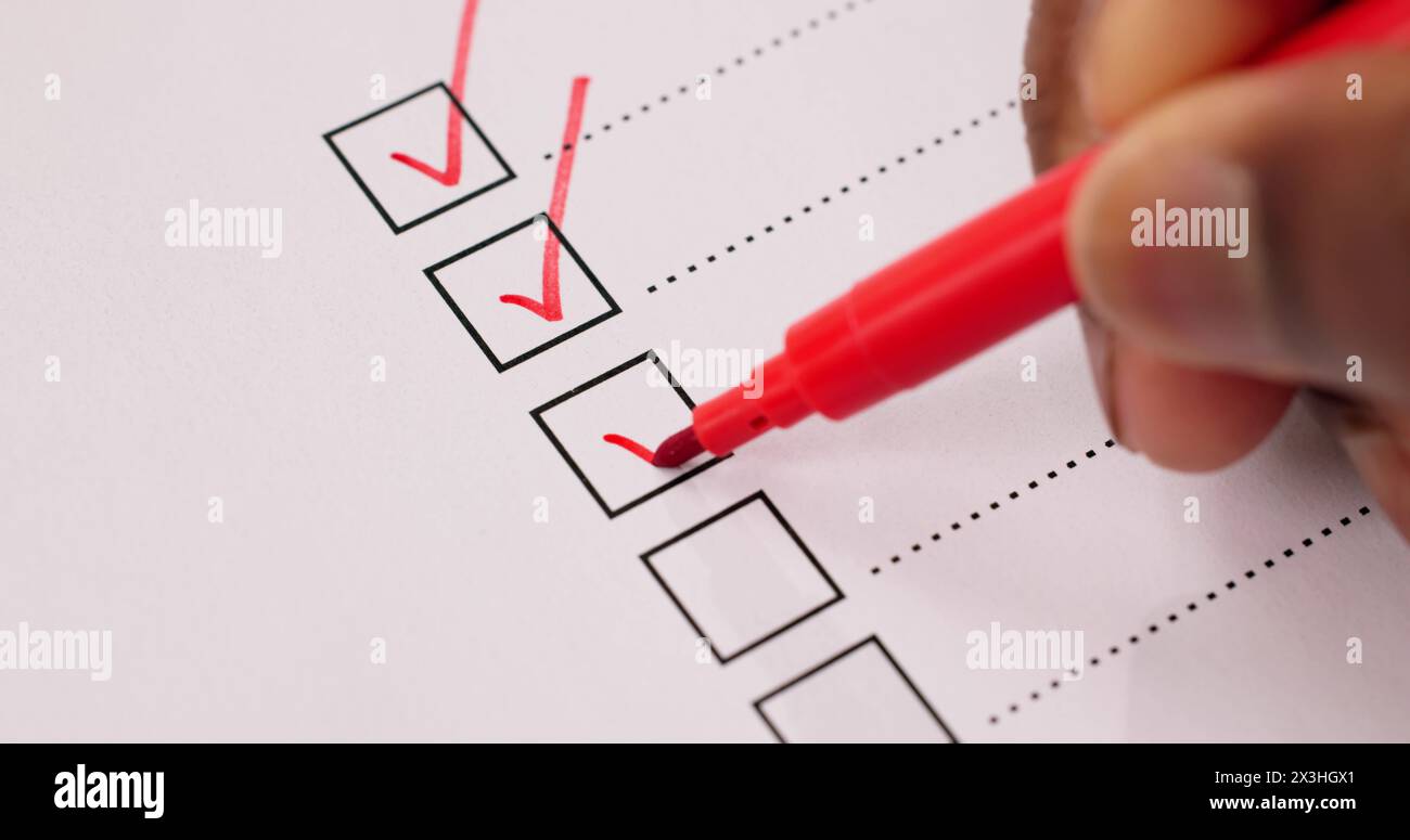 African American Hand Marking Check Mark In Checklist Survey Stock Photo