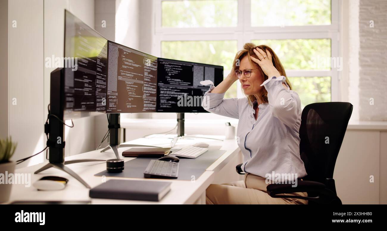 Unhappy Sad Developer Programmer Woman In Stress Coding Software On Computer Stock Photo